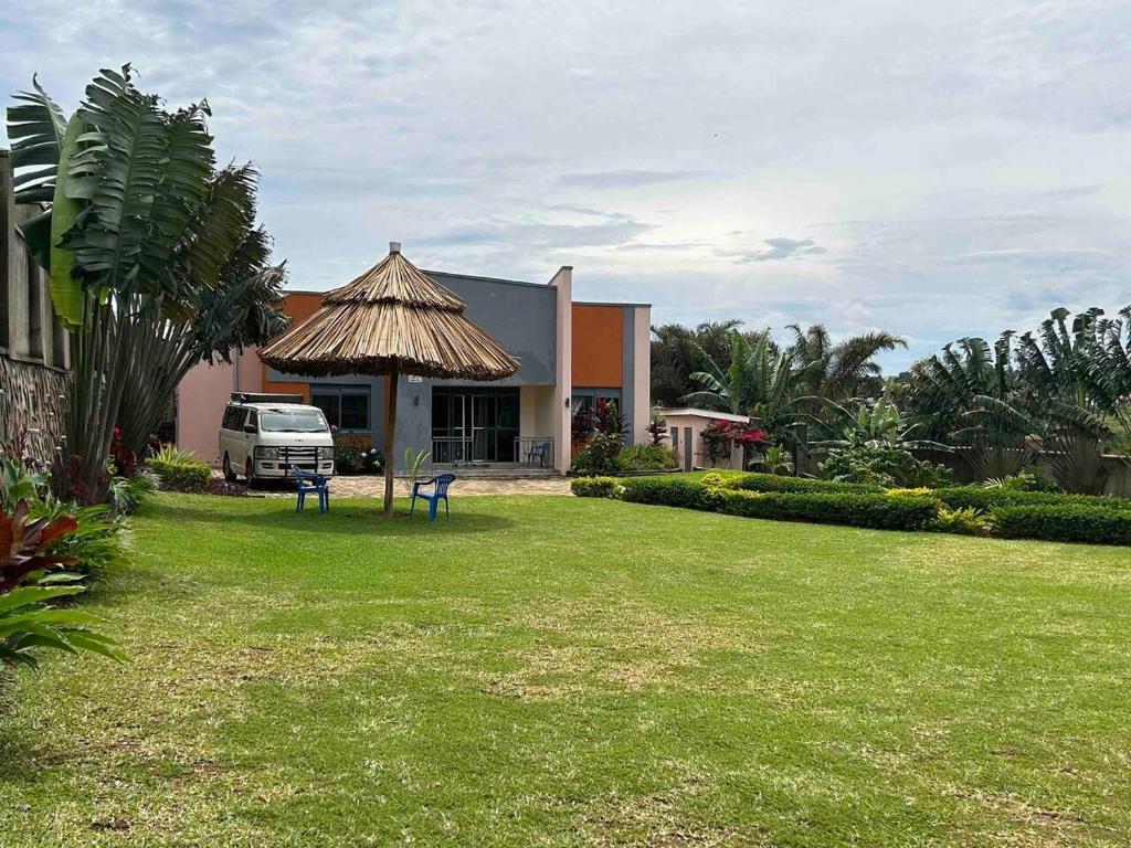 恩德培Amazing lake Victoria Villa, Entebbe的前面有一辆面包车,房子有草地庭院