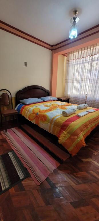 科帕卡巴纳Hostal Sol y Luna的一间卧室配有一张带五颜六色棉被的床