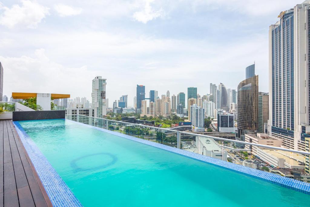 Loma del NaranjoBoutique Apartments Panamá Marbella的一座城市天际线建筑屋顶上的游泳池