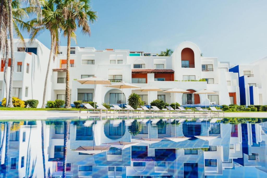 圣克鲁斯华特库瓦图尔科扎阿斯拉卡米奥真实酒店的一座拥有游泳池和棕榈树的酒店
