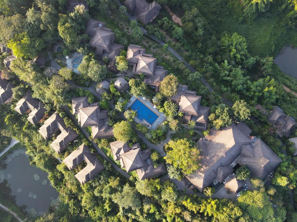 湄斯乐奈清莱山Spa度假酒店的享有一座树木和水景的建筑的顶部景色