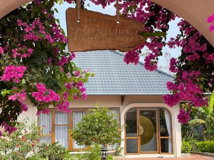 伊缇天福GOLDEN LOTUS SPA & HOMESTAY的前面有粉红色花的房子