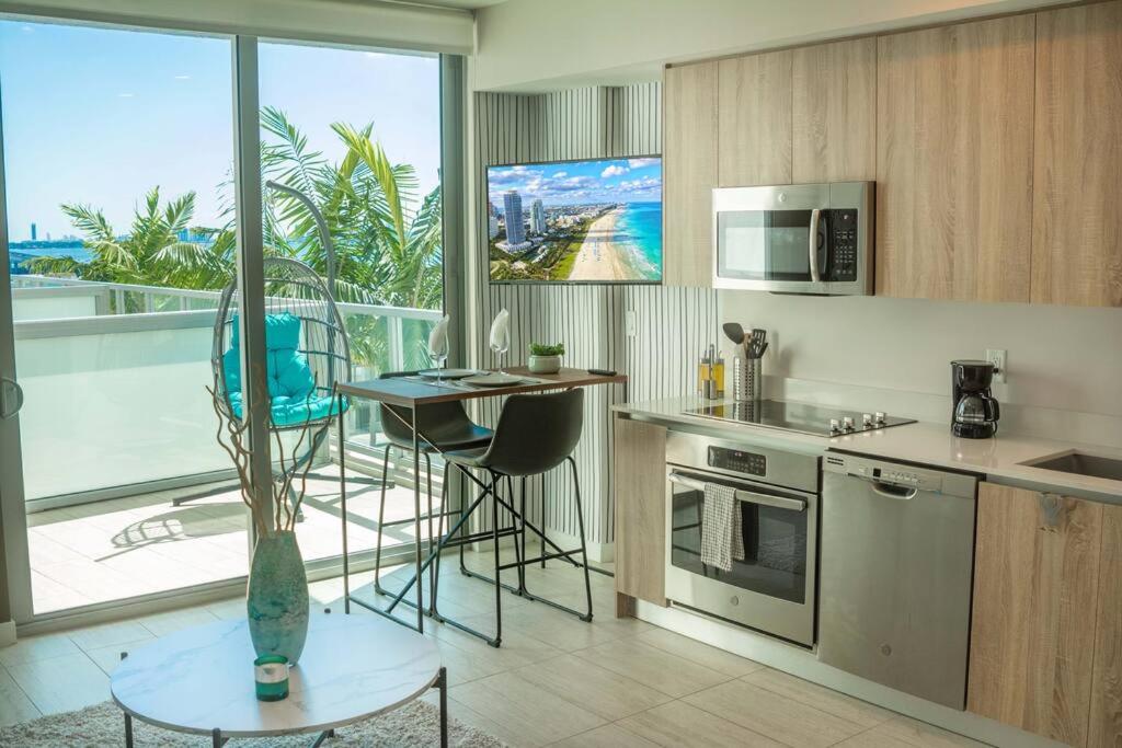 迈阿密Luxury Oceanview Studio at Miami Design District的带桌子的厨房和带阳台的厨房