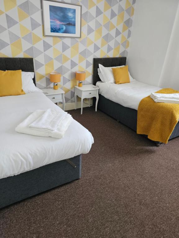莫珀斯The Trap Inn的配有黄色枕头的酒店客房的两张床
