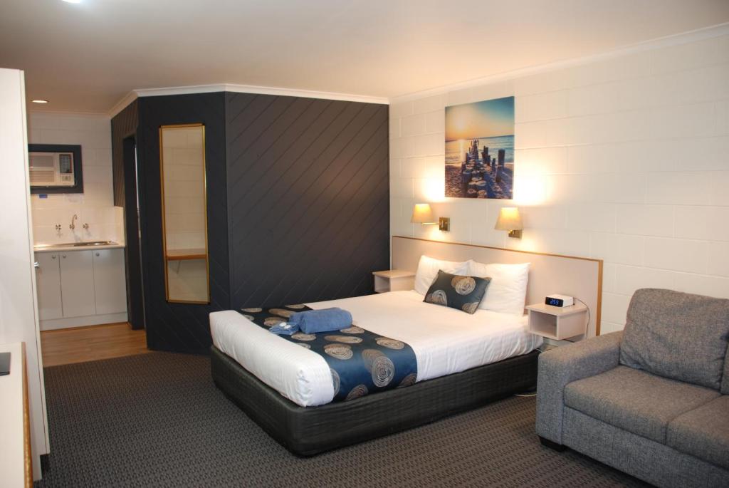 莱克斯恩特伦斯坎宁安海岸金链汽车旅馆的一间卧室配有一张床、一张沙发和一把椅子
