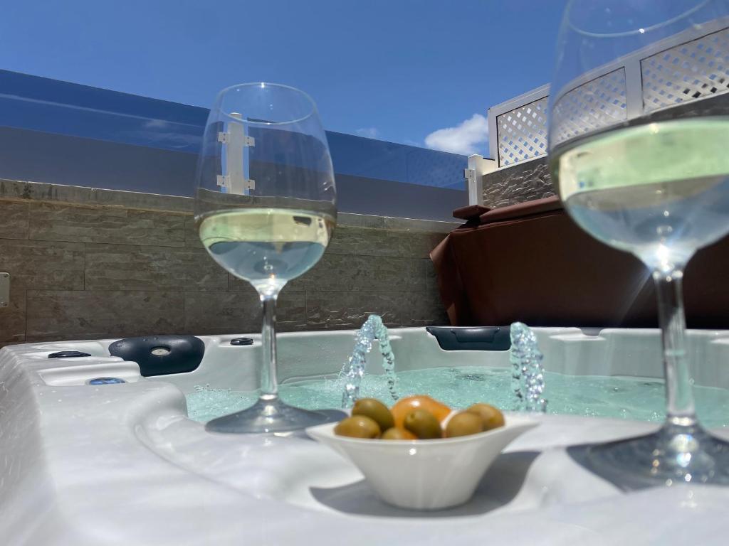 波多黎各Apartment With Jacuzzi and pool access的浴缸里放两杯葡萄酒和一碗西红柿