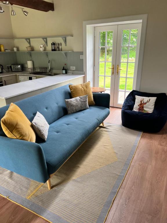 布莱尔高里Blairbeg Cottage的客厅里一张蓝色的沙发