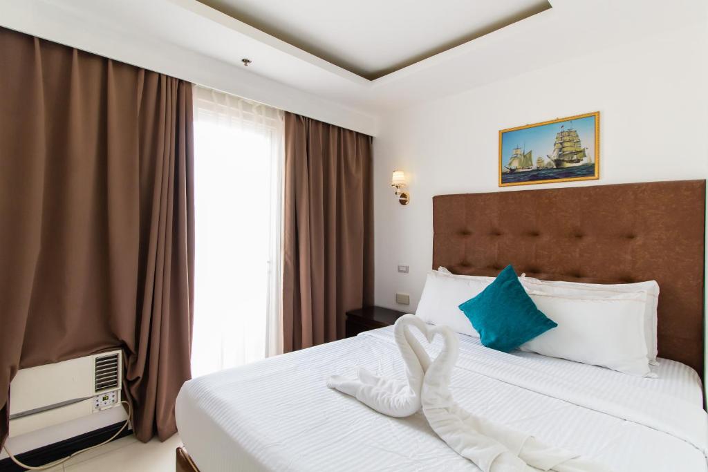 马尼拉Pacific Bay Grand Suites的酒店客房设有床和窗户。