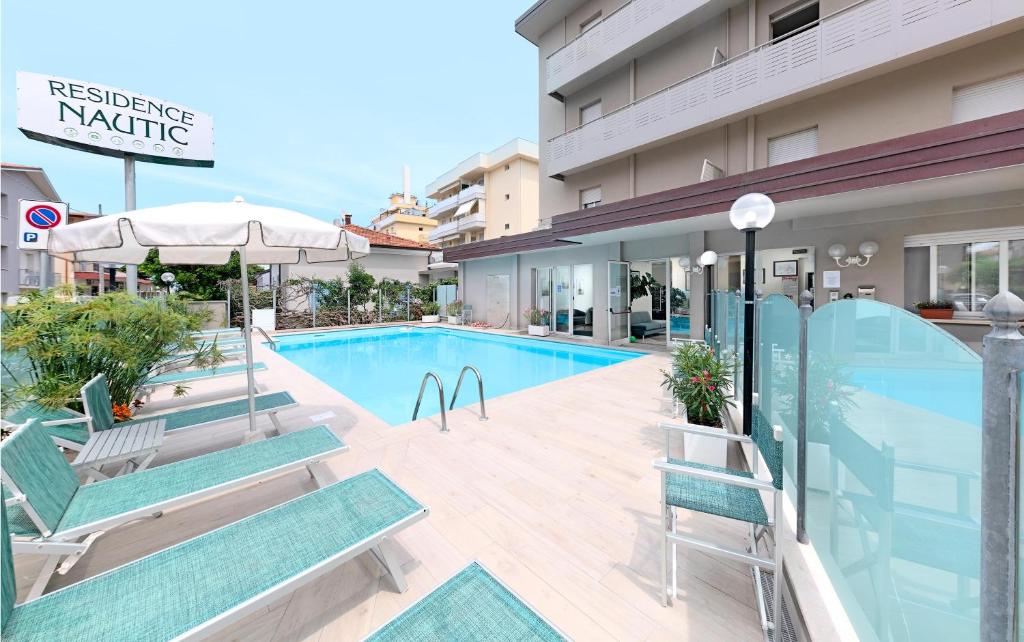 里米尼纳欧迪旅馆的一座带椅子的酒店游泳池,一座建筑
