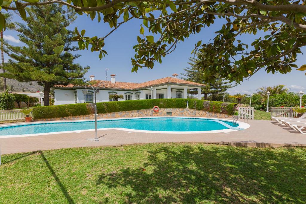 多列毛利诺斯Villa Galemar Pool & Gardens的房屋前的游泳池