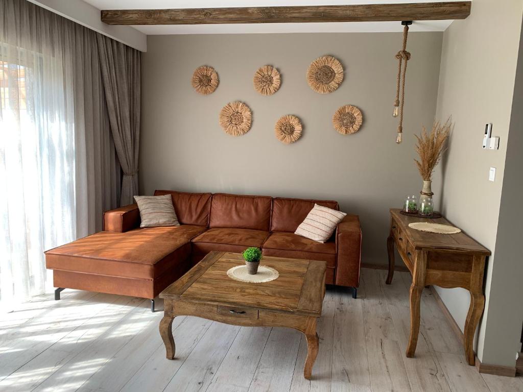 特兹萨茨Domek Mirage Garden的客厅配有棕色沙发和桌子