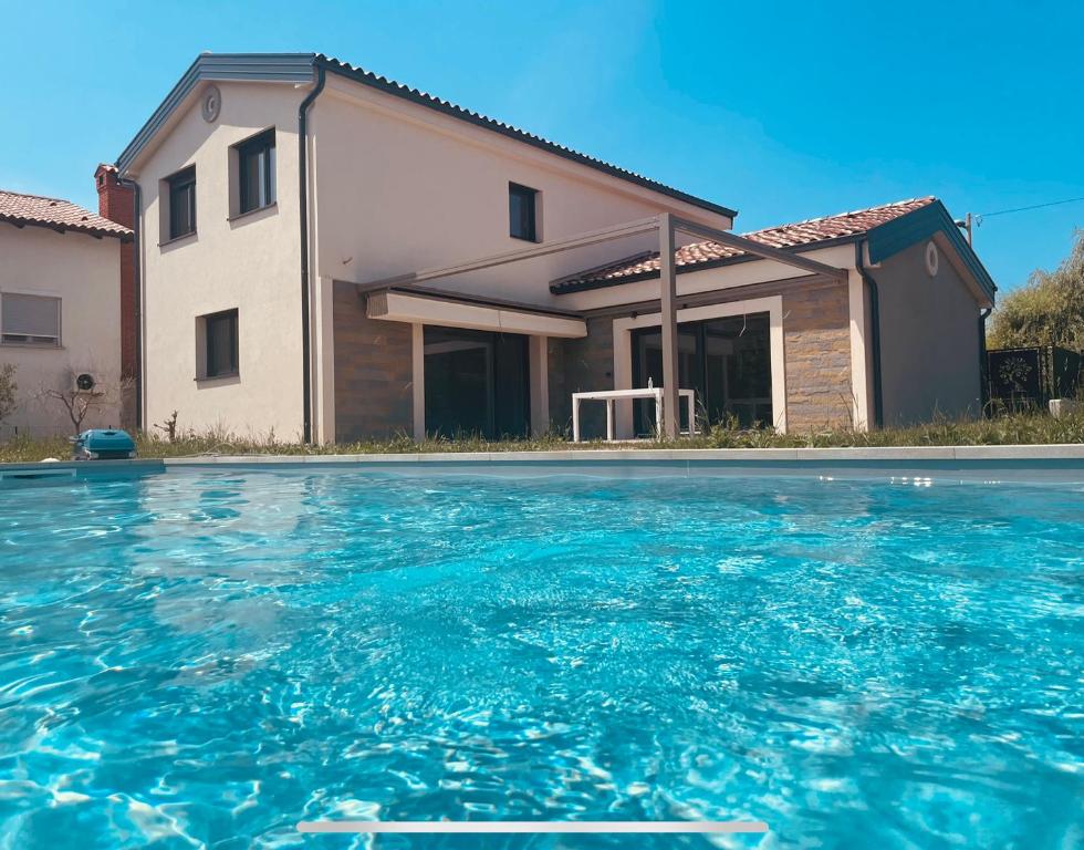 科佩尔Paradise villa with private swimming pool的房屋前有游泳池的房子