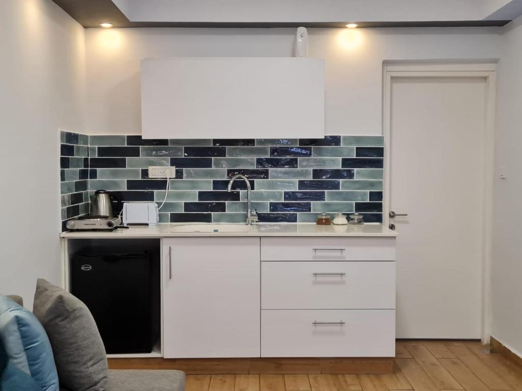 埃拉特Suite4u的厨房配有白色橱柜和砖墙