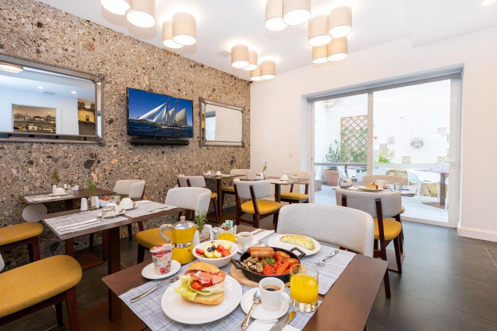 维多利亚Battistini Boutique Living Hotel and Spa, Victoria, Gozo的一间餐厅配有桌椅,提供食物