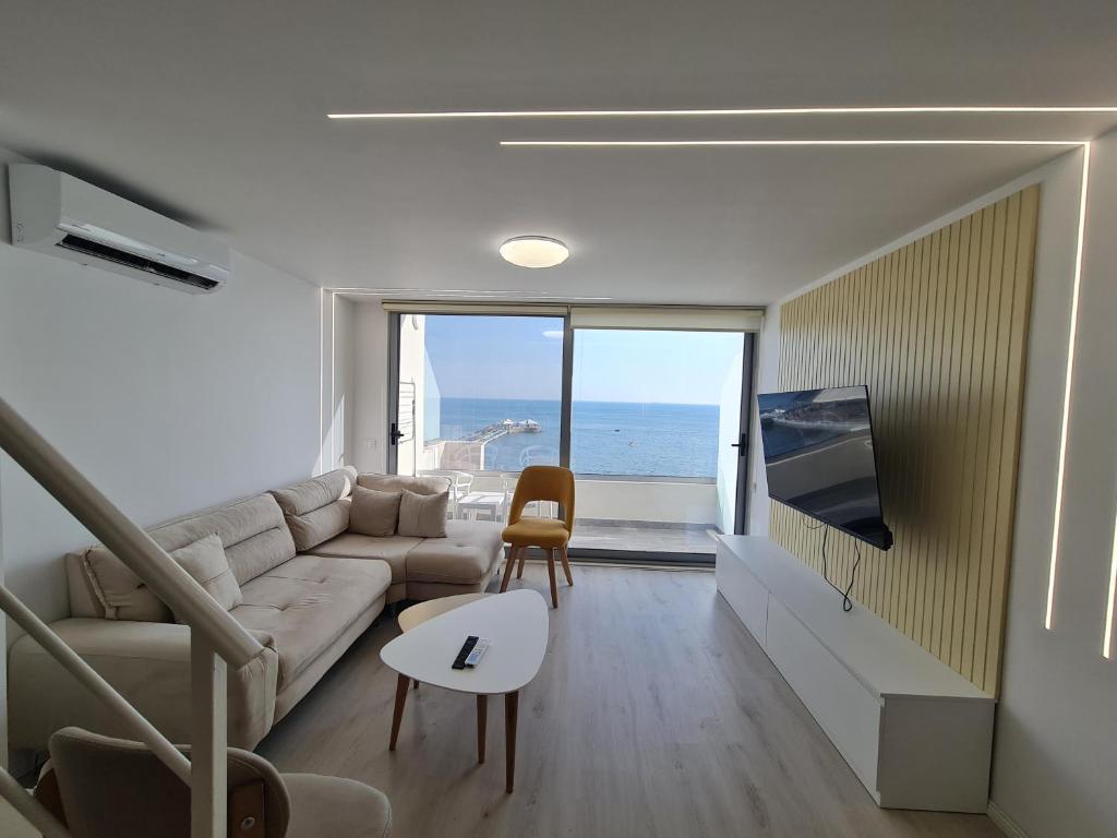 都拉斯Sea view luxury duplex的带沙发的客厅,享有海景