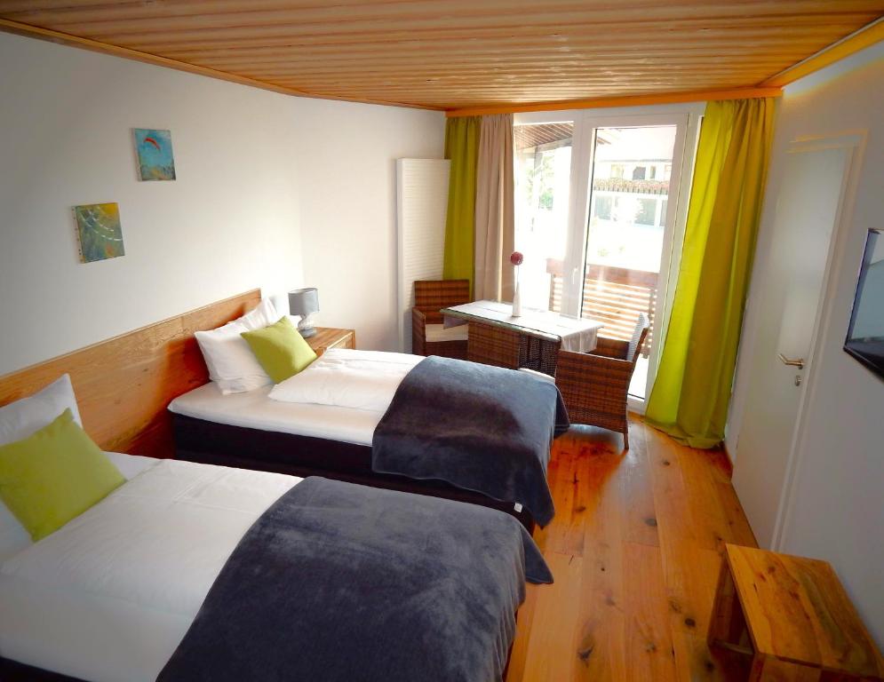 上施陶芬Vital Lodge Allgäu mit Oberstaufen PLUS的酒店客房设有两张床和窗户。