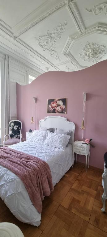 Ma petite folie的卧室配有白色的床和粉红色的墙壁