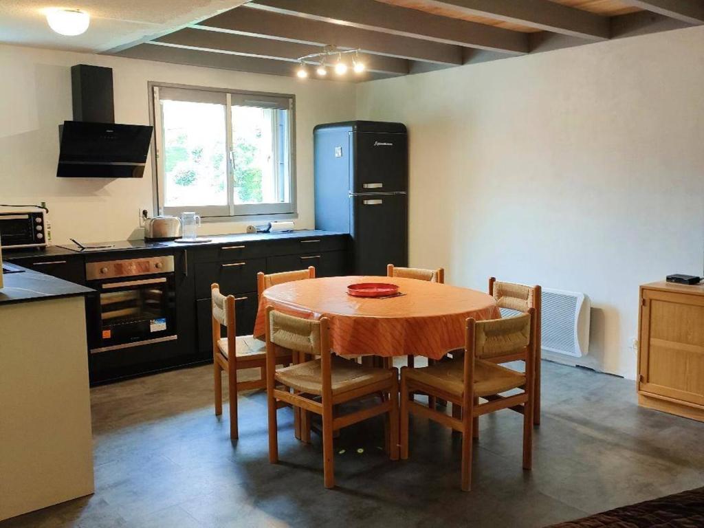 科特雷Appartement Cauterets, 3 pièces, 6 personnes - FR-1-234-252的厨房配有桌椅和冰箱。