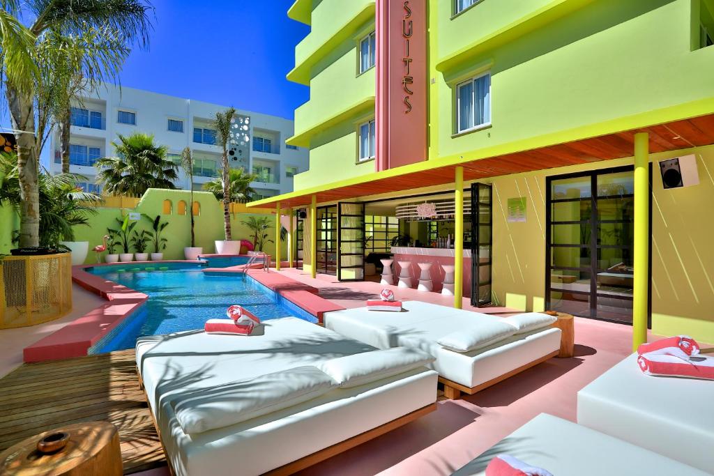 普拉亚登博萨Tropicana Ibiza Suites - Adults Only的一座酒店,旁边设有一座游泳池,