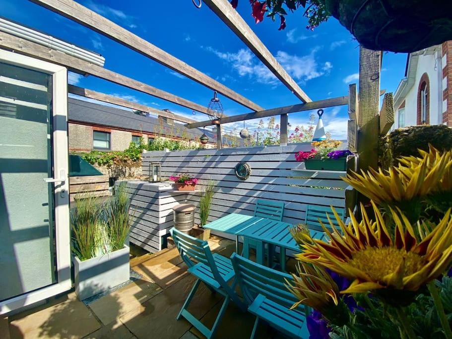 戈尔韦Cozy Retreat in The City Centre的一个带蓝色长凳和一些植物的庭院