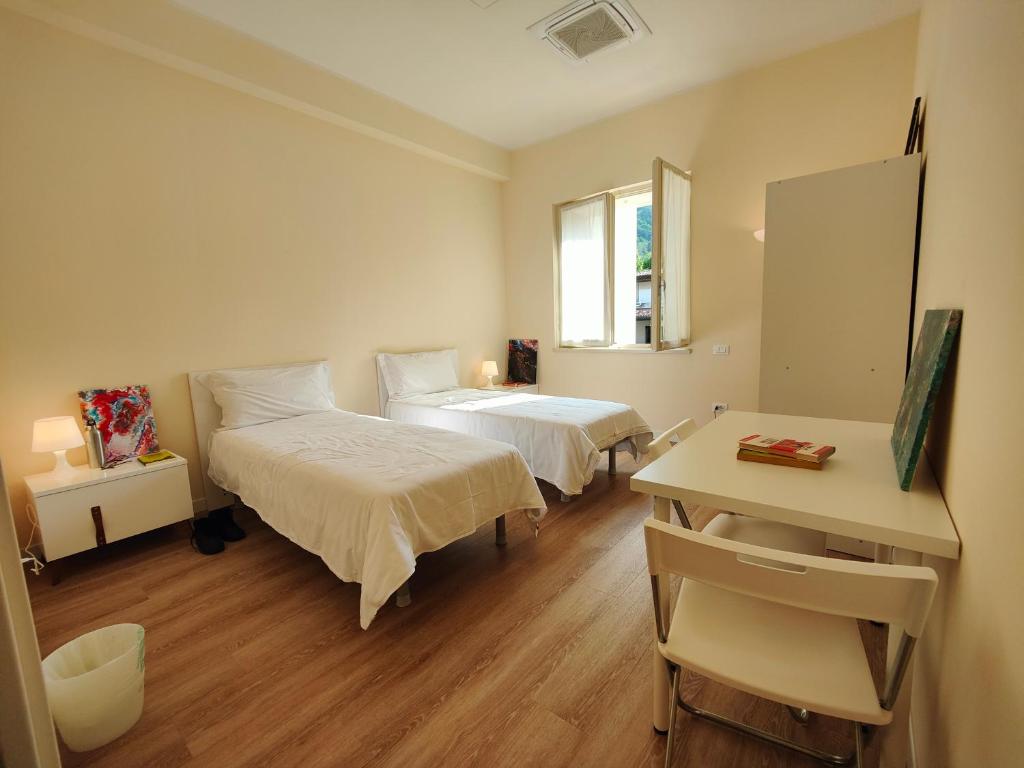 维托里奥·威尼托Casa dello Studente的客房设有两张床、一张桌子和一面镜子。