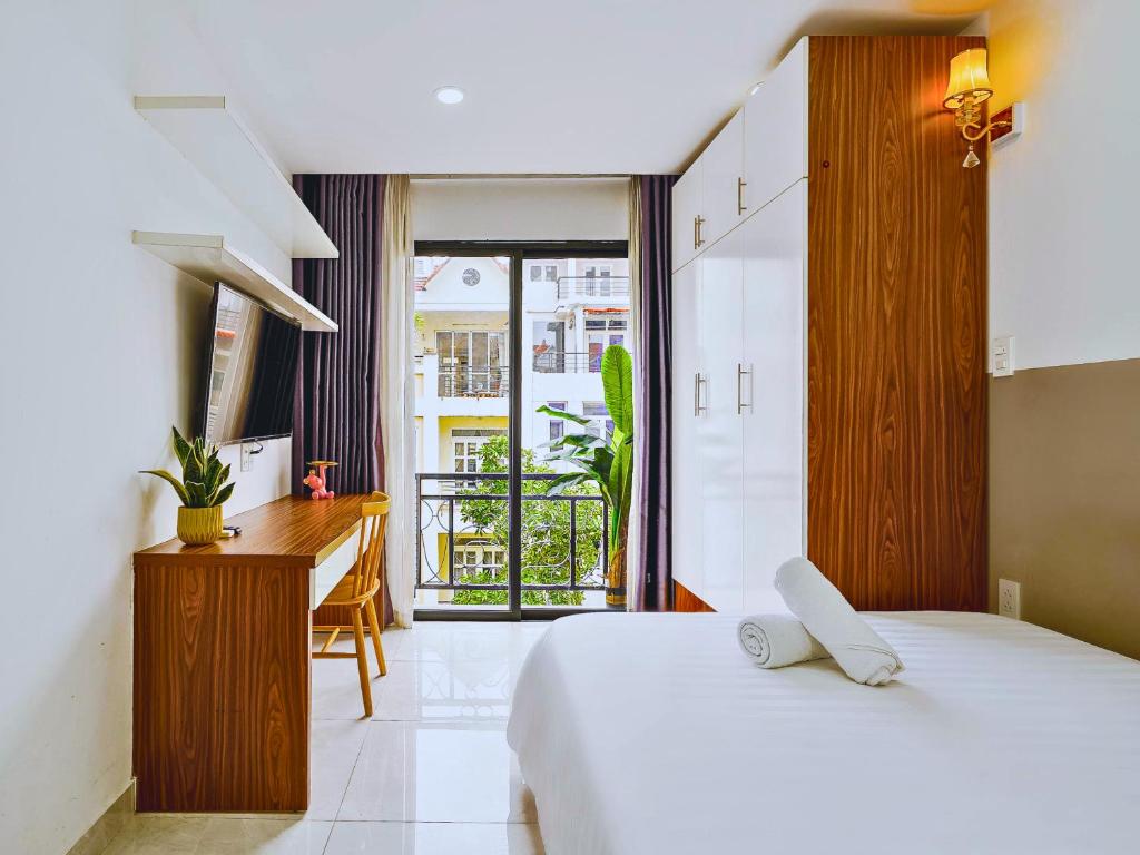 胡志明市Spring Hill Apartment -The High Class的一间卧室配有一张床、一张书桌和一个窗户。