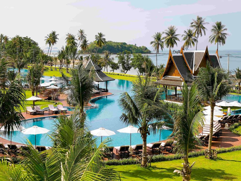 功孟海滩Sofitel Krabi Phokeethra Golf and Spa Resort的享有度假村的空中景致,设有游泳池和棕榈树