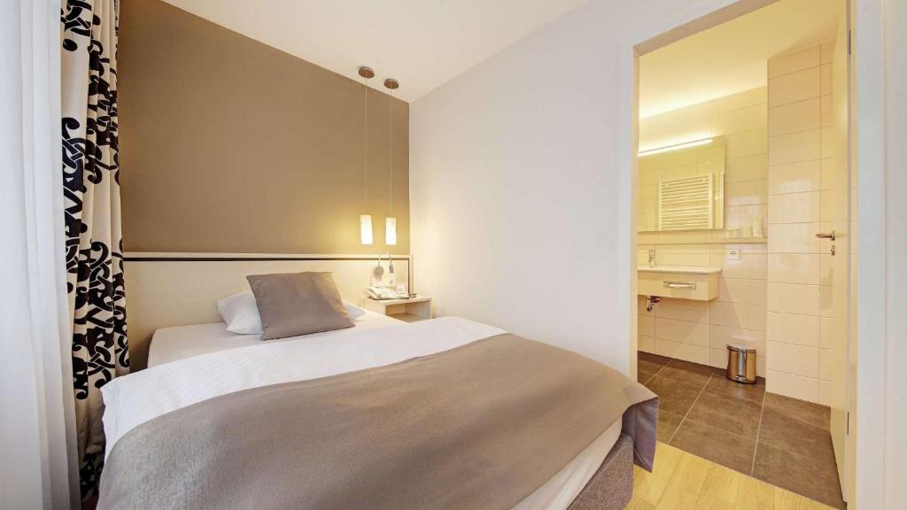 菲尔德施塔特Hotel Schwanen Stuttgart Airport/Messe的一间带床的小卧室和一间浴室
