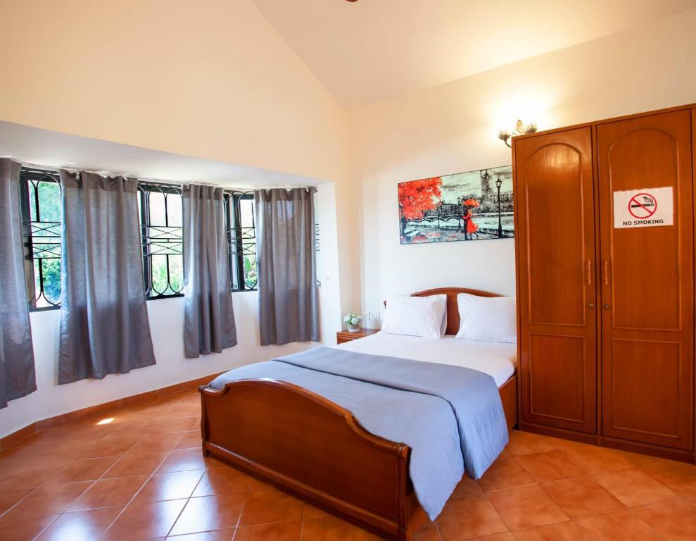 马尔冈'Golden Coral' 2bhk Benaulim Beach villa Goa的一间卧室配有床、橱柜和窗户。