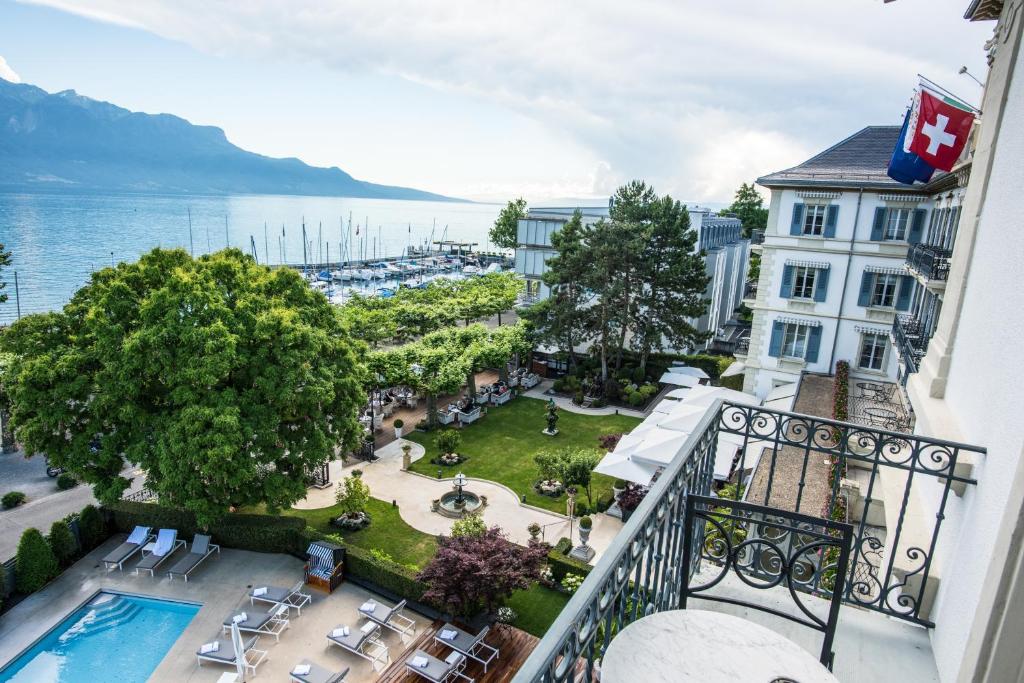 沃韦Grand Hotel du Lac - Relais & Châteaux的从带游泳池的酒店阳台欣赏风景