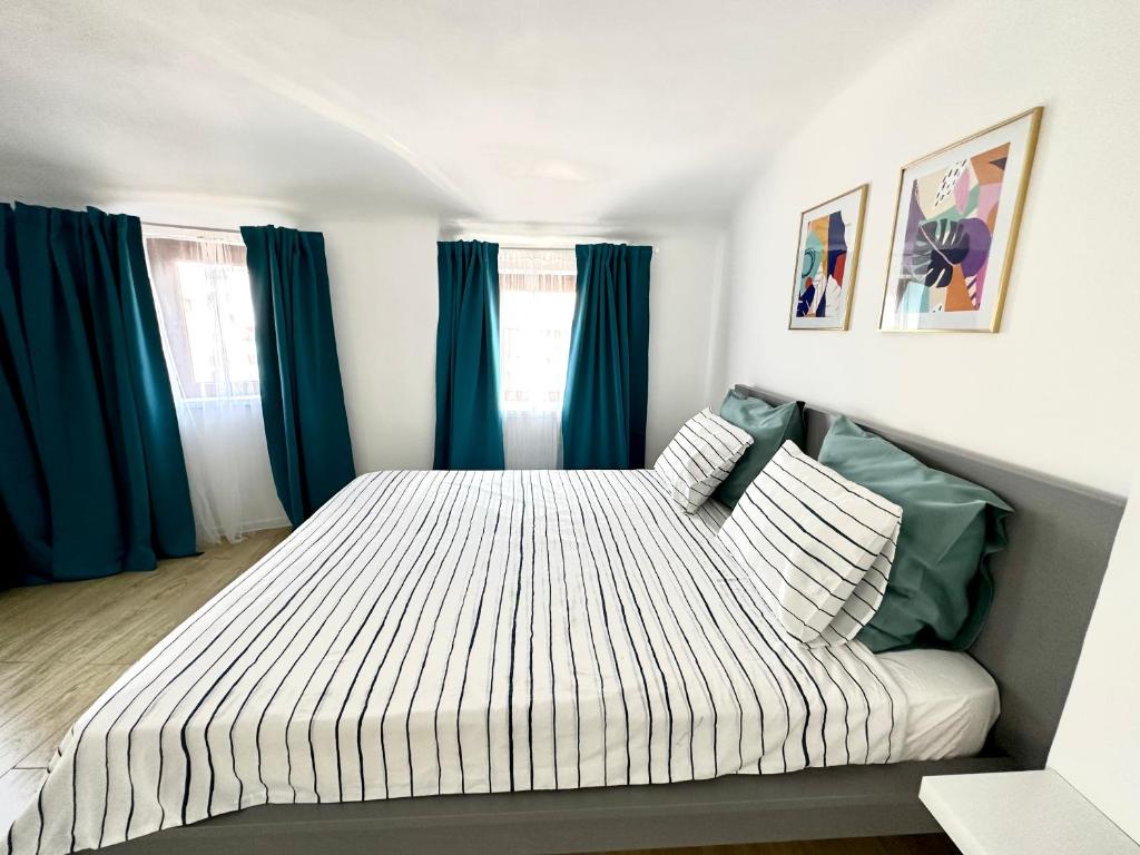 布加勒斯特Turqoise Central Apartaments的一间卧室配有一张带蓝色窗帘的大床