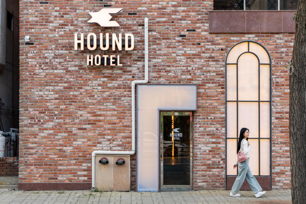 堤川市Jecheon Hound Hotel的一位妇女走进一家酒店