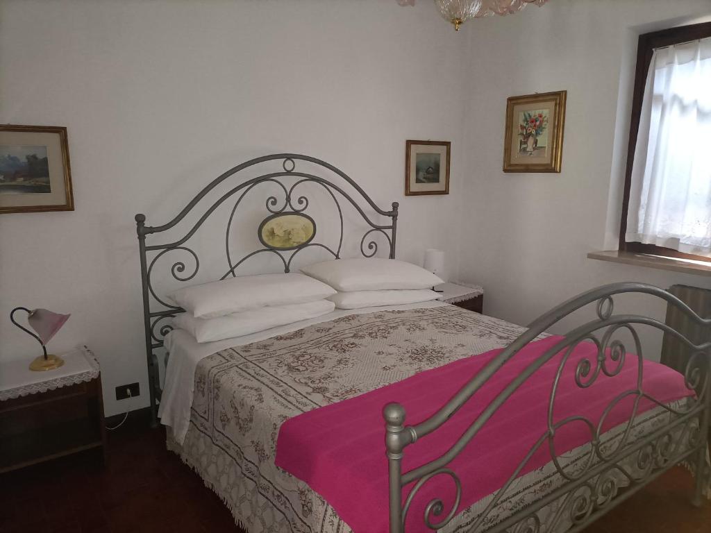 科奥恩B&B le rose的一间卧室配有一张床铺,床上铺有粉色毯子