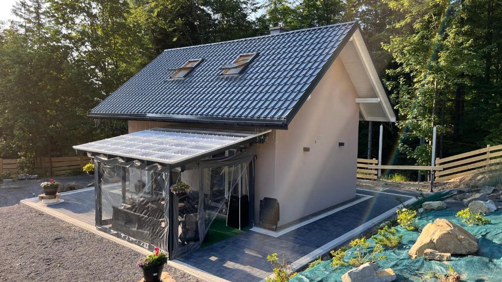 乌斯特龙Domek Pierwiosnek Ustroń的花园中带太阳能屋顶的小房子