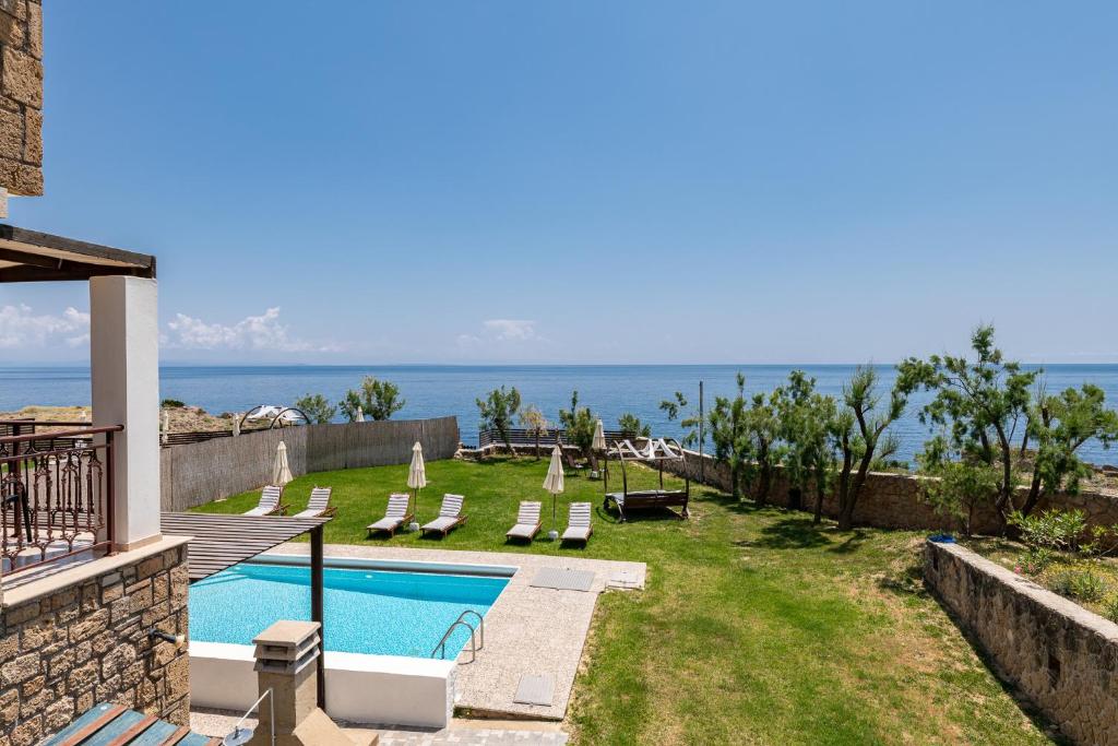 瓦西里科斯Armonia Seaside Villas的一个带游泳池和大海的后院