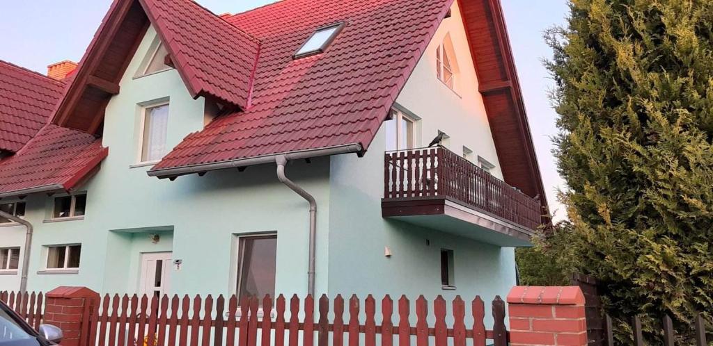 雅罗斯瓦维茨U Izy i Romana的白色的房子,有红色的屋顶和栅栏