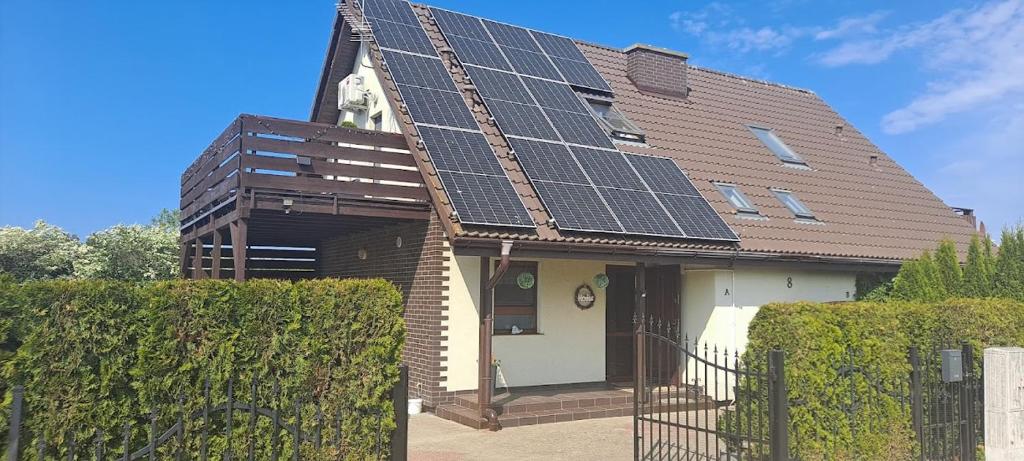 博格泽利卡DOMEK-NADMORSKI ZAKĄTEK的屋顶上设有太阳能电池板的房子