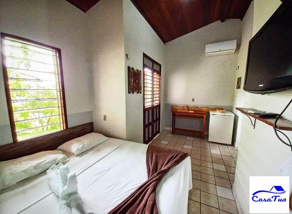 皮帕Casa Tua Pipa的一间卧室配有一张床和一台平面电视
