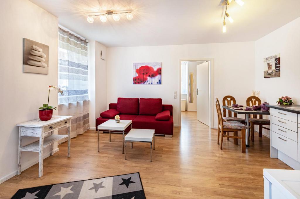 莱茵费尔登Ferienwohnung Am Bach的客厅配有红色的沙发和桌子