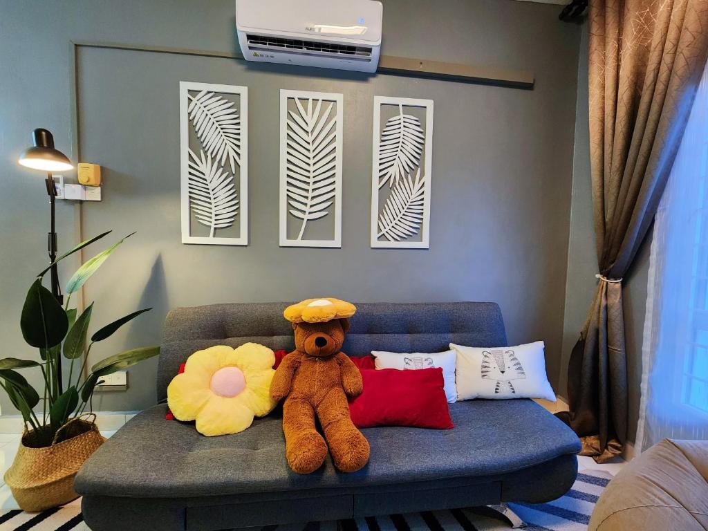 莎阿南Shah Alam U8 FULLY AIR-CON Suite的客厅的沙发上坐着泰迪熊