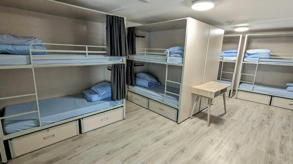 利物浦国际旅馆的客房配有4张双层床和蓝色枕头。