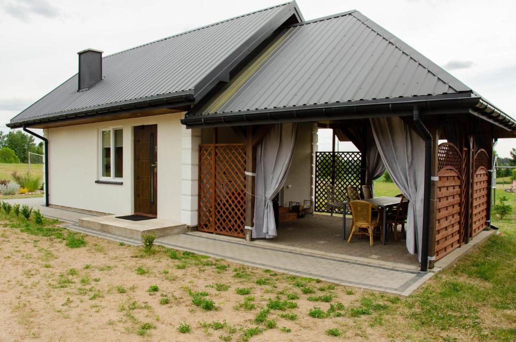 FilipówDomki na Wzgórzu - Rospuda - Domek z sauną的白色的小小屋,设有黑色屋顶