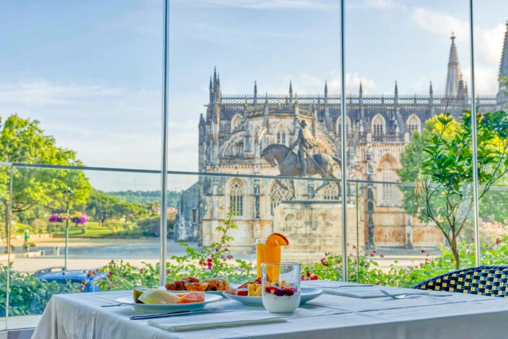 巴塔拉Hotel Lis Batalha的一张桌子,上面有食物,享有建筑的景色