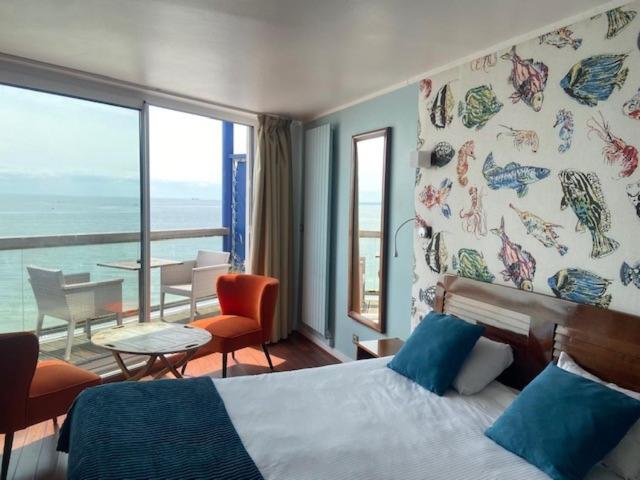 勒阿弗尔LOGIS HOTEL - La Petite Rade的一间卧室配有一张床,享有海景