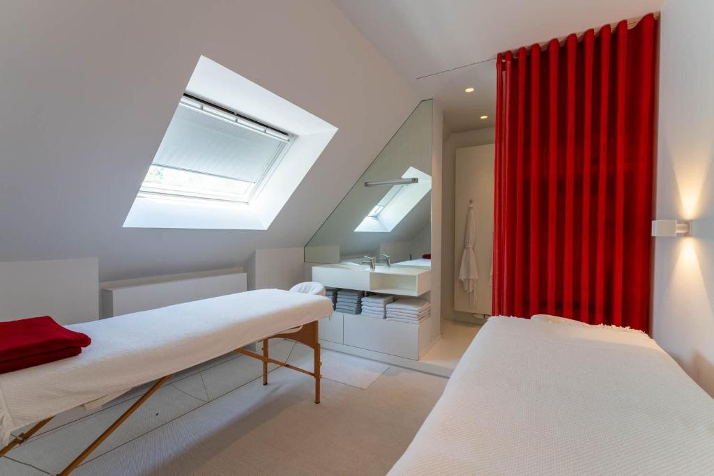 布兰肯贝赫Polderlicht的一间设有两张床和红色窗帘的房间