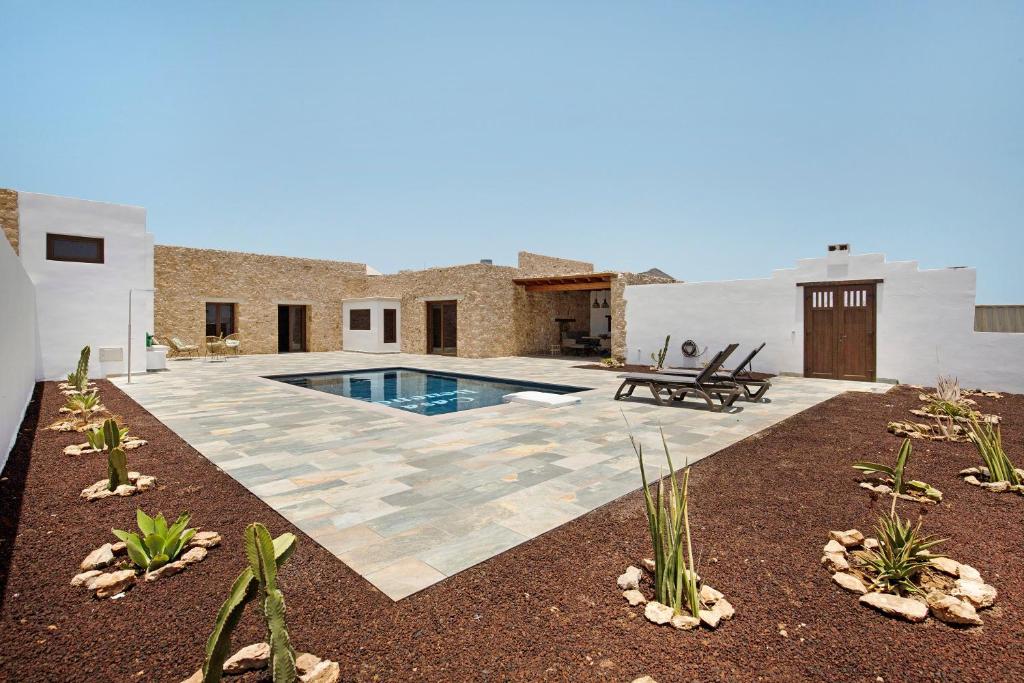 TiscamanitaCasa Rural Berrenda的一个带游泳池和房子的后院
