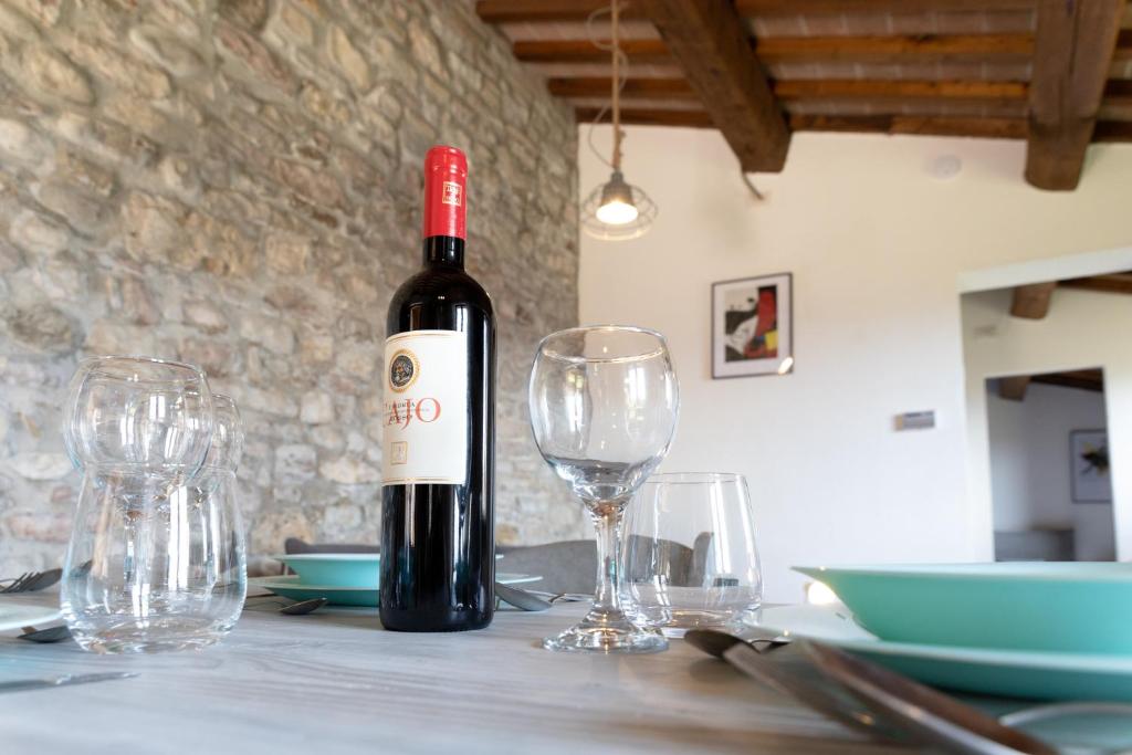 阿西西Rustic House, con patio e giardino, Assisi centro的桌子上摆放着一瓶葡萄酒和眼镜