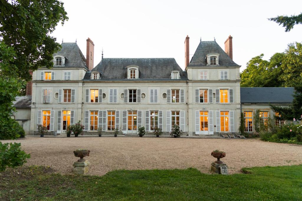 奥利韦Château du Rondon的一座大型白色房子,拥有橙色门窗