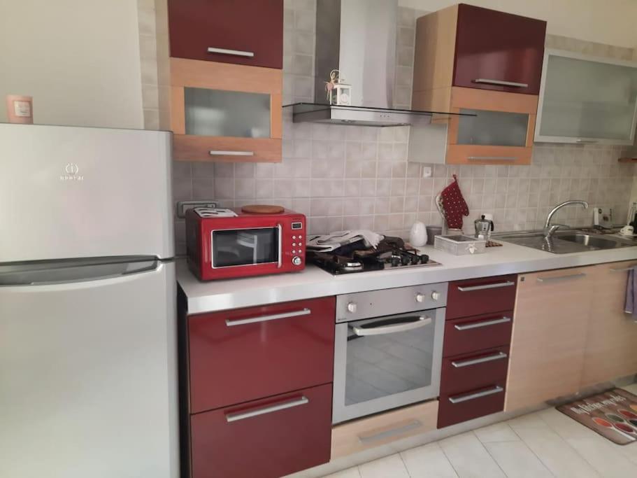 卡利亚里Stylish Loft Trivano Cagliari 2 beds/2 bath的厨房配有白色冰箱和红色微波炉