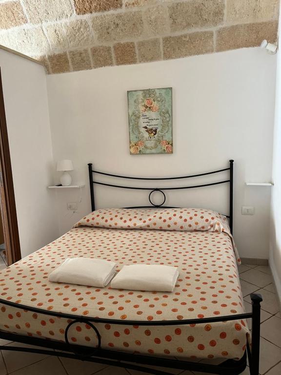 滨海波利尼亚诺Dimora dei Pellegrini的一间卧室配有一张带两个枕头的床